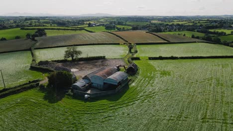 barns and farmhouse in irish countryside, tilt up aerial view