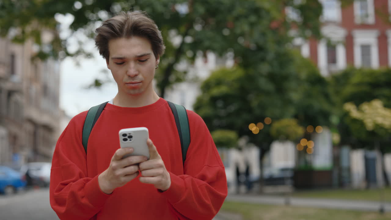 Young man using smartphone on city street