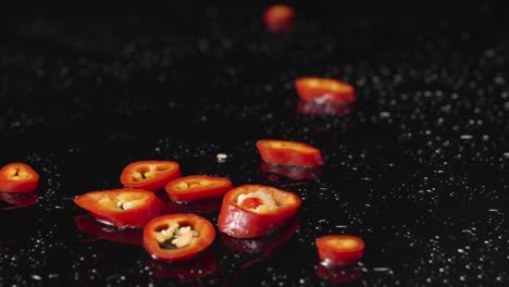 sliced red chili peppers on a dark background