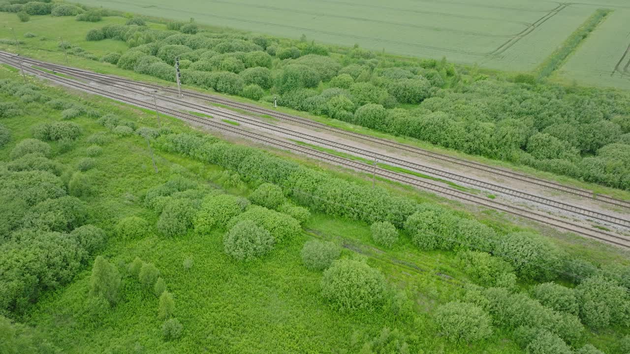 빈 철도 열차 트랙, 시골 풍경,  ⁇ 에 신선한 녹색 숲, 구름이 가득한 여름 날, 넓은 드론 새 눈  ⁇  앞으로 이동, 아래로 기울어