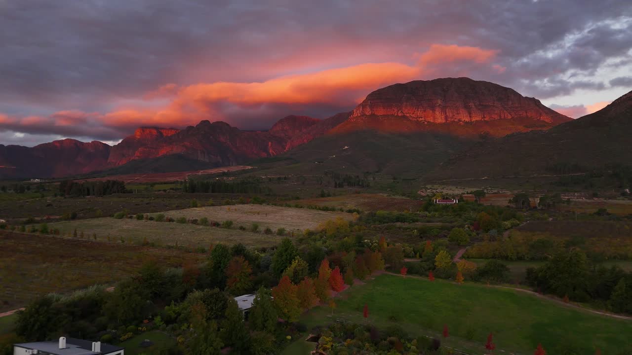 Sunset creates crimson clouds over mountains and vineyards in Stellenbosch, South Africa