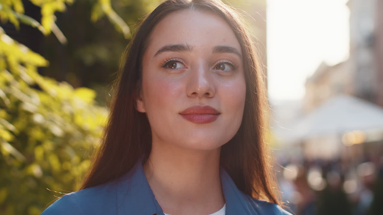 feliz mujer joven sonriendo mirando lejos soñando descansando buenas noticias sentirse satisfecho en la calle de la ciudad