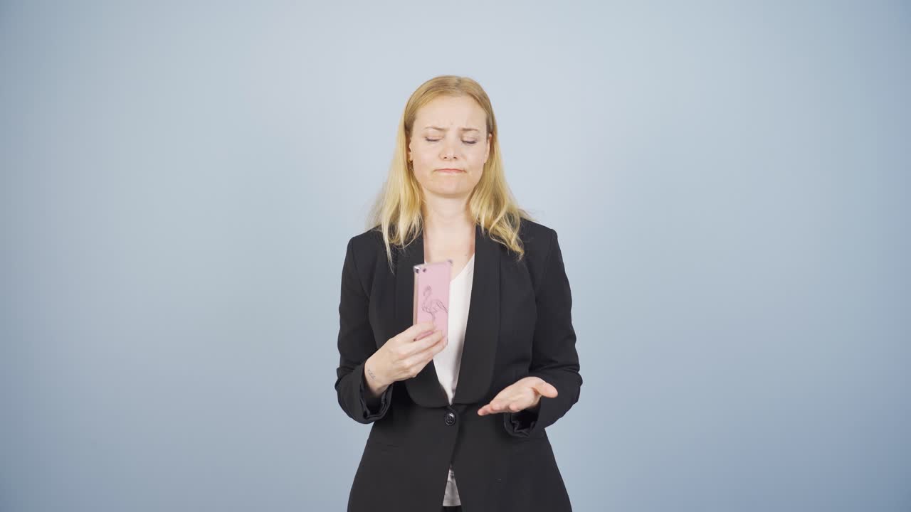 스트레스를 받은 비즈니스 여인, 손에 전화, अनिश्चित한 표정.