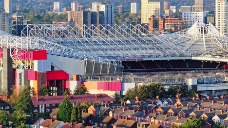 tomada aérea del famoso estadio old trafford y el vecindario en manchester durante la puesta de sol dorada