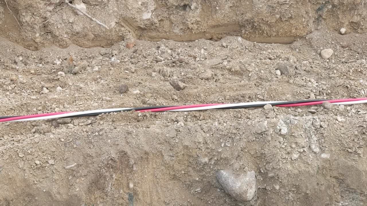 gran cable de alimentación de tres hilos que se arrastra a través de un sitio de construcción