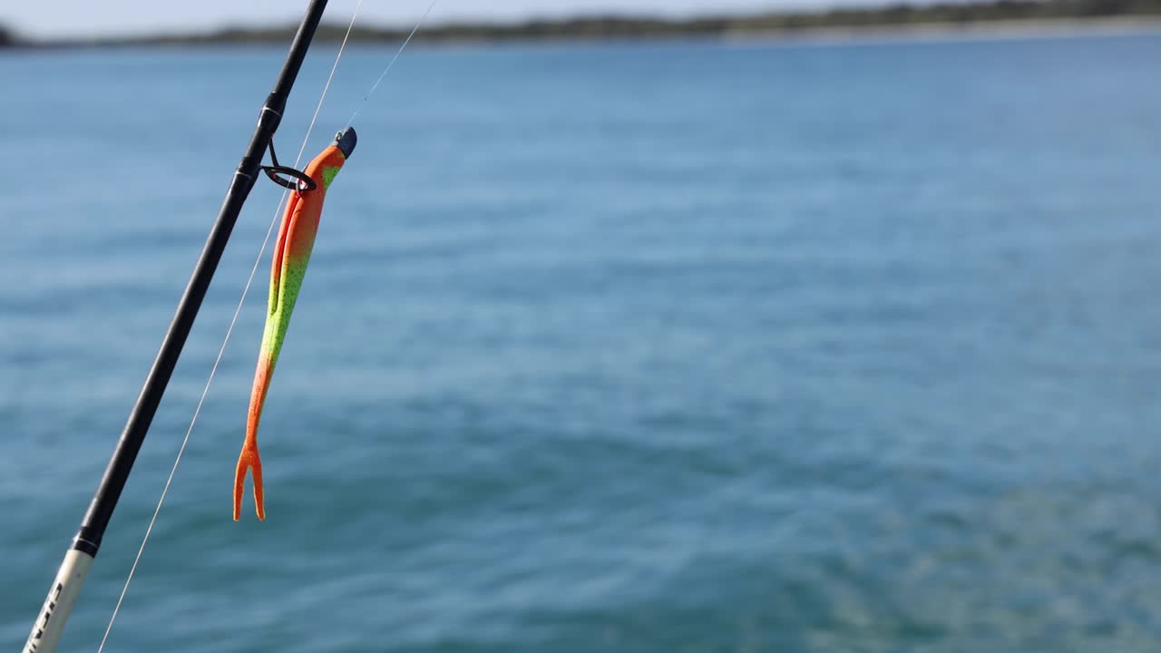Fishing rod with lure over calm waters