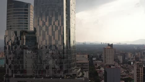 imágenes ascendentes de edificios modernos de vidrio de oficinas altas. cielo nublado dramático antes de una fuerte lluvia. ciudad de méxico, méxico