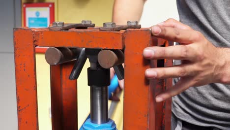 Slow-motion-shot-of-a-metal-bar-bending-clamp-being-operated-by-an-engineering-student
