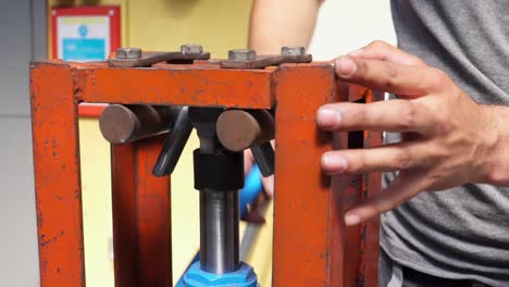 slow motion shot of a metal bar bending clamp being operated by an engineering student