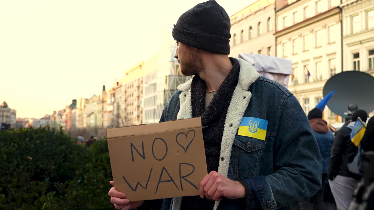 Manifestante con cartello contro la guerra a una manifestazione per l'Ucraina a Praga