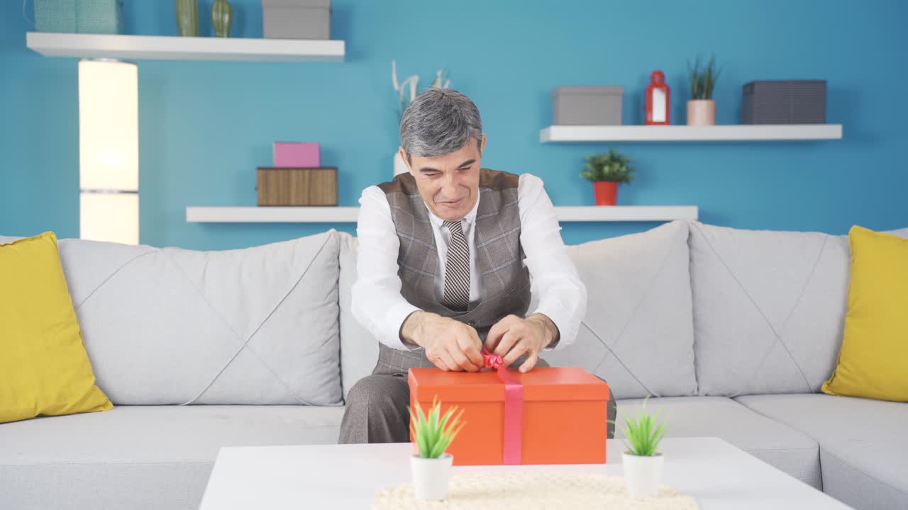 그  ⁇ 은이는 아이들로부터 받은 선물 상자를 열고 매우 행복합니다.