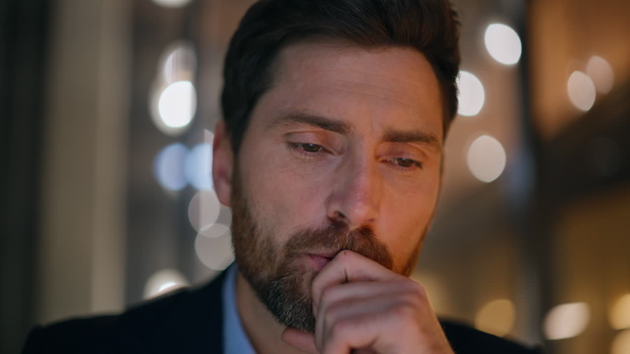 Businessman pondering business strategy at dark workplace closeup. Serious man