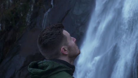 Close-Up-Man-Admiring-Awesome-Power-Of-Natural-With-Flowing-Waterfall