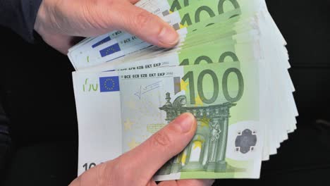 woman counting one hundred euro bills in her hands