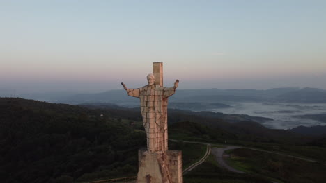 Reveal-of-a-huge-concrete-statue-at-the-top-of-a-mountain