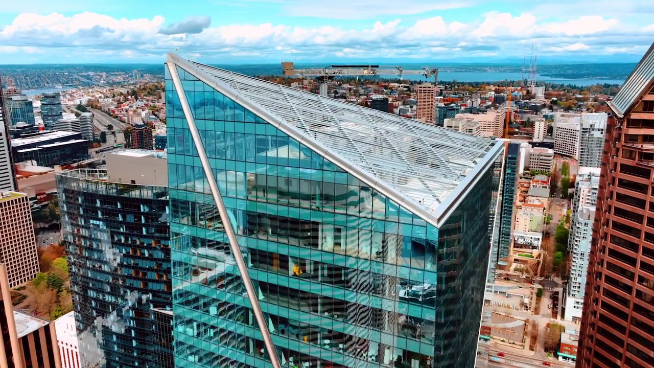 Acercándose a la cima de un rascacielos con techo inclinado. Vista panorámica de Seattle, Washington, Estados Unidos, al fondo.