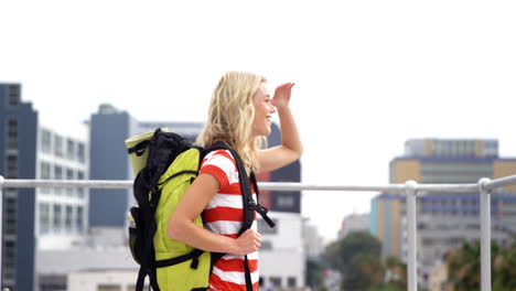 smiling hipster with backpack visiting a city