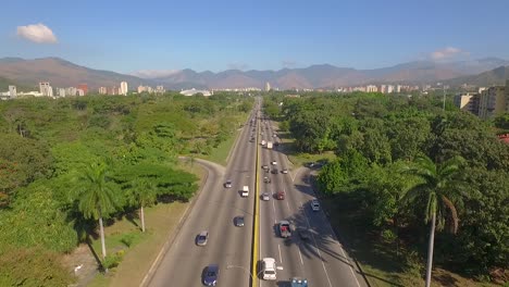 Vista-Aérea-De-Una-Carretera-En-Valencia,-Carabobo,-Venezuela,-Junto-A-Un-Parque-Verde