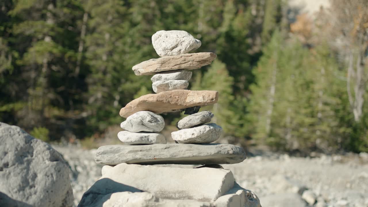 밝은 빛 아래에 건조한 강바닥에 작은 사람이 만든 바위 이누크수이트 동상