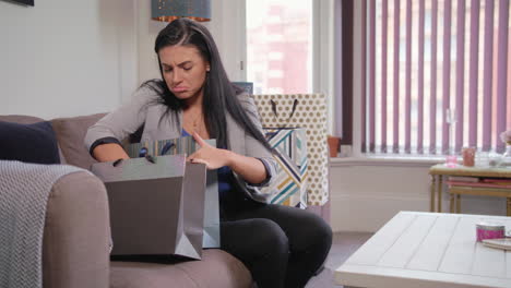 slow motion shot of young beautiful woman looking through her shopping bags only to realise that she has forgotten something, then uses her smart phone to order the missing product