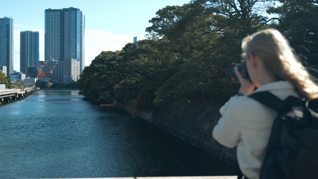 A serene shot of a photographer immersed in capturing the beauty of Hamarikyu Gardens in Tokyo.
