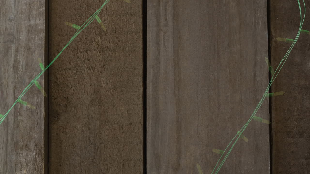 Animation of flickering fairy lights with copy space on wooden background