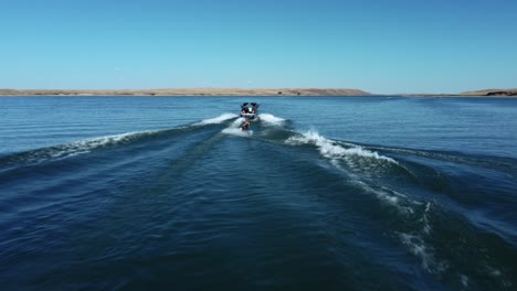 flying after wakeboarder and powerboat on the lake in summertime in canada