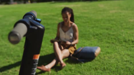 Mujer-Afroamericana-Sentada-Sobre-El-Césped-Leyendo-Un-Libro-En-El-Parque