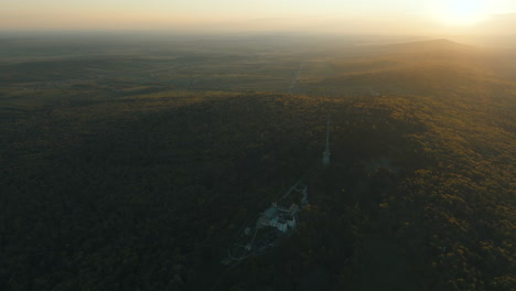 aerial sunset view of a castle nestled in a forest
