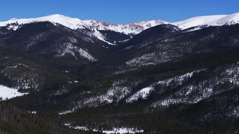 boreas mountain pass breckenridge colorado aerial drone cinematic backcountry sunny blue clear sky north fork tiger road bald rocky mountains winter fresh snow snowmobile forward pan up motion