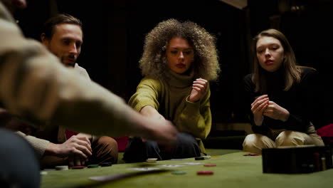 bottom view of group of friends playing poker sitting on the couch in the living room