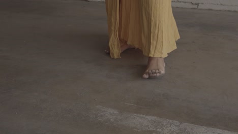 african american woman in yellow dress standing barefoot dancing slowly