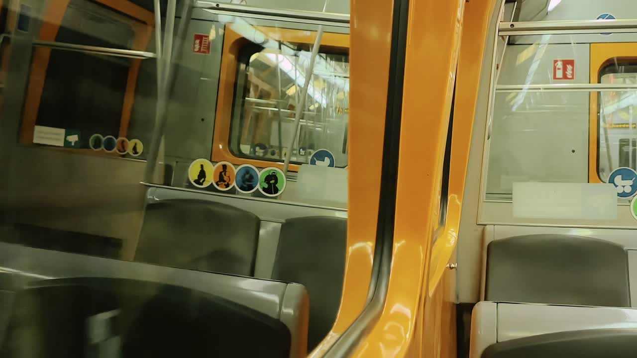 modern subway train interior with yellow seats and signs under bright lighting in empty carriage