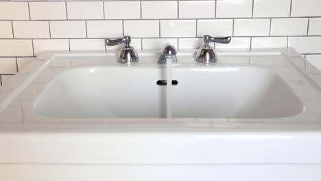 man turns clean white sink on