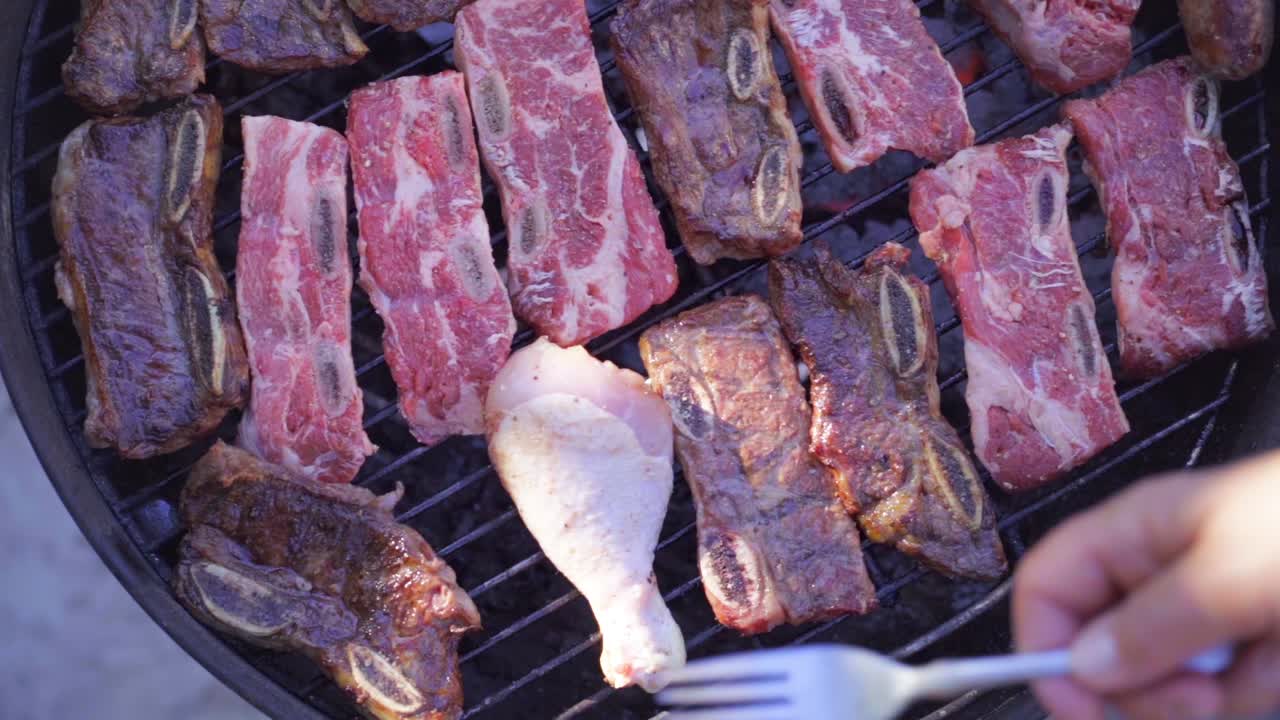 바비큐에서 라틴계 손으로 갈비, 닭고기, 소시지를 요리하는 모습