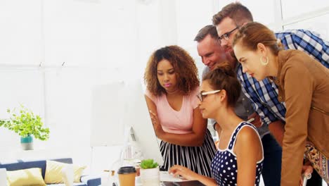 Team-of-executives-discussing-over-computer-in-the-office