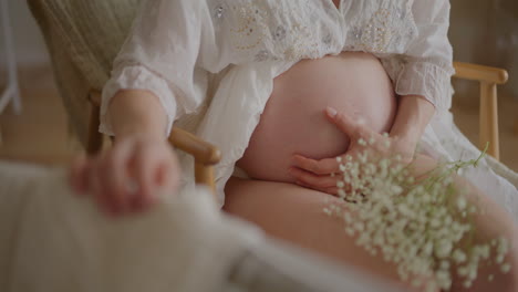 pregnant woman cradling newborn in rocking chair