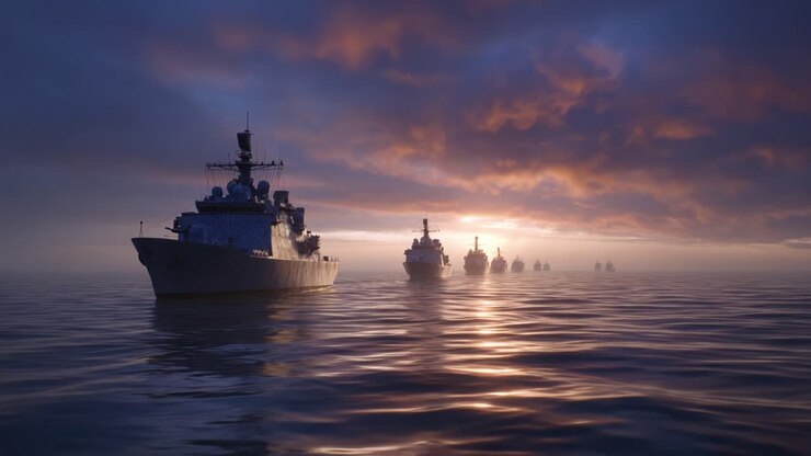 Navi da guerra navigano tranquillamente alla luce del mattino. L'alba dorata si riflette sulle onde dell'oceano. La flotta si muove all'unisono attraverso l'orizzonte. Una scena marittima pacifica evoca precisione militare. Ideale per la marina e la difesa.