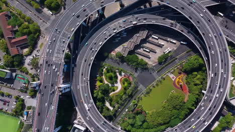 vista aérea de arriba hacia abajo que muestra el tráfico en un paso elevado de intercambio de varios niveles y un intercambio elevado o una intersección de autopista con tráfico urbano ocupado