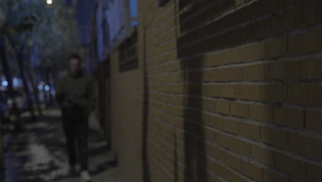 person walking at night in an alley