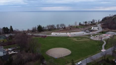 Drone-Volando-Lejos-Del-Parque-Junto-Al-Lago-En-Primavera