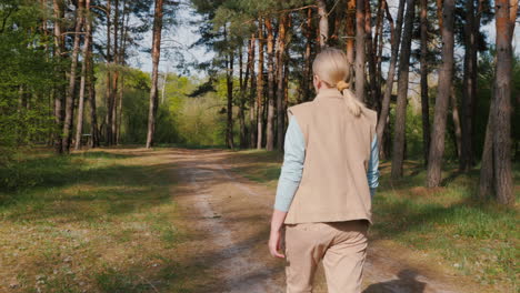 woman walking through a pine forest