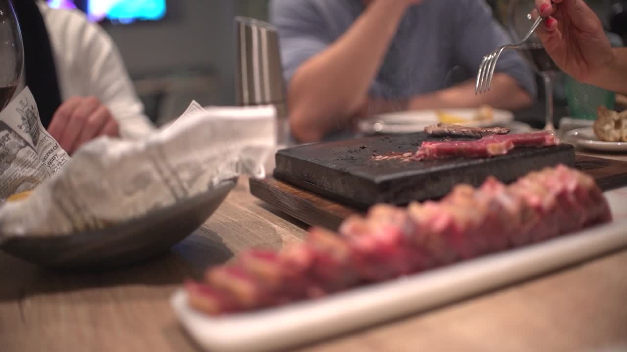 식당에서 생일을 축하하는 식당에서 식사하는 친구들, 토스트, 환호, 핫스톤에서 자신의 고기 준비