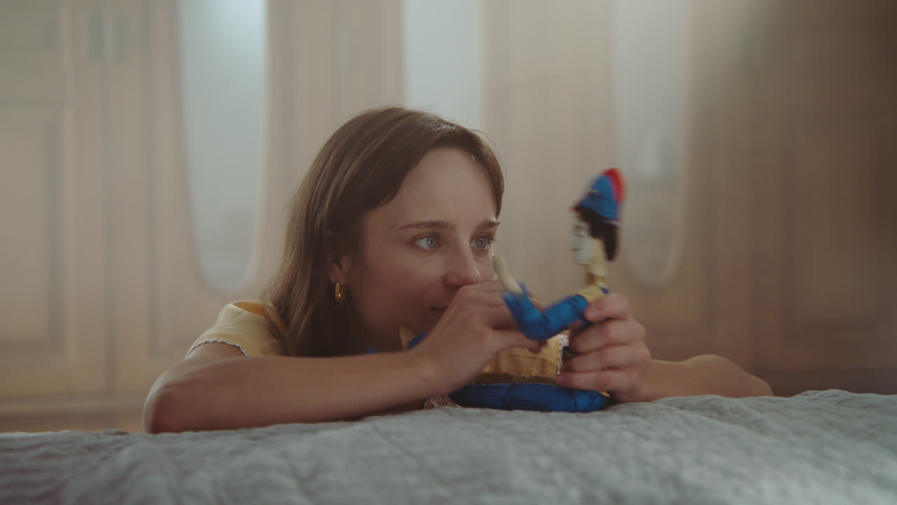 A girl playing with dolls in her room