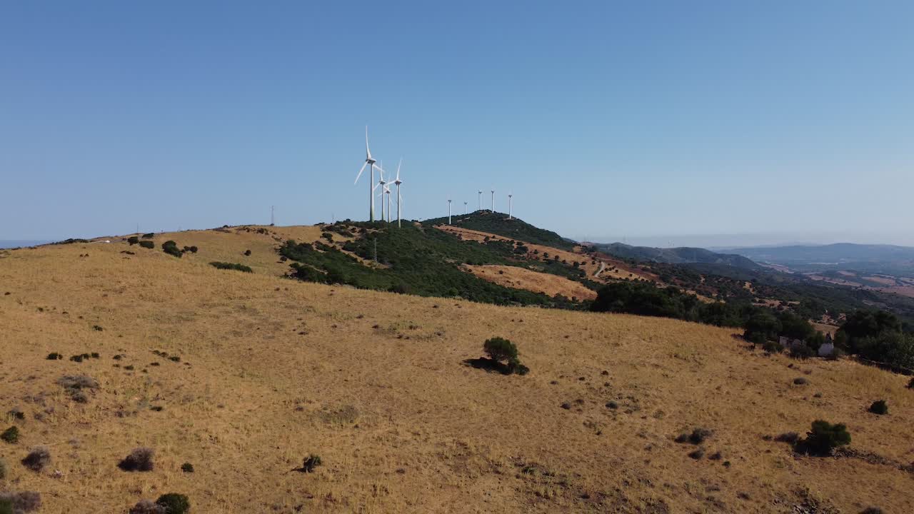 molinos de viento giratorios que generan energía verde en suelo español, vista aérea descendente