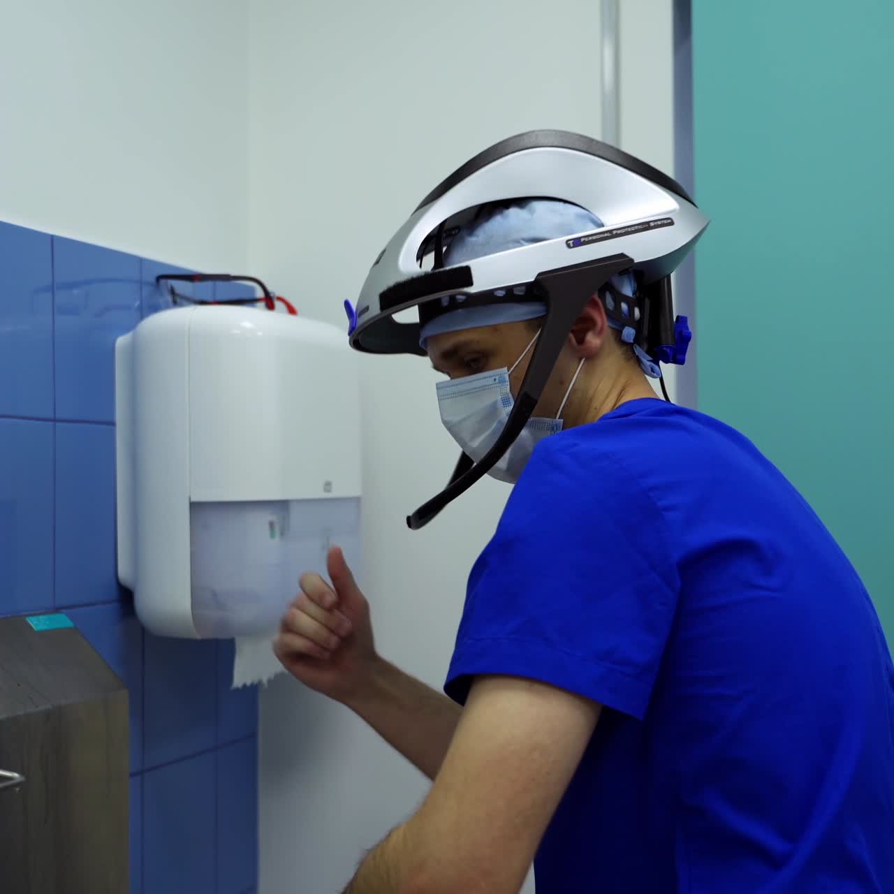 Doctor washes hands. Surgeon in safety cap and mask disinfects his hands thoroughly in the cleaning room. Hygiene before the surgery.
