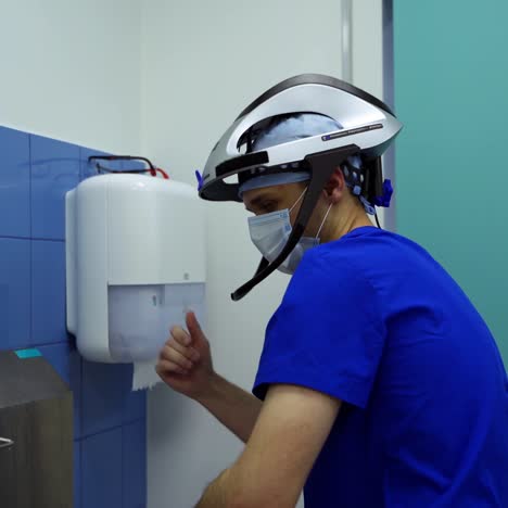 doctor washes hands. surgeon in safety cap and mask disinfects his hands thoroughly in the cleaning room. hygiene before the surgery.