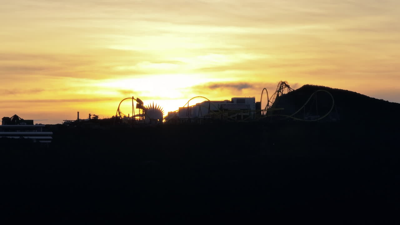 colorida puesta de sol al anochecer en el fondo de un parque de atracciones
