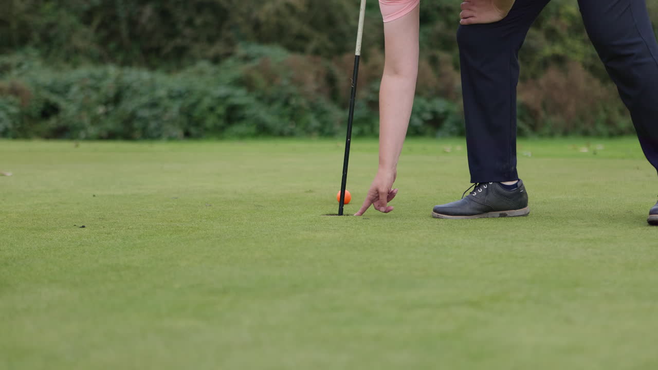 Golf ball being putted into a hole
