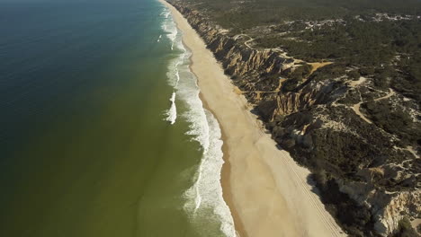 Hermoso-Paisaje-De-Bosque-Rocoso-Y-Olas-Salpicando-En-La-Costa-Arenosa-De-Gale,-Cerca-Del-Camping-Praia-Da-Gale-En-Portugal---Toma-Aérea-De-Drones